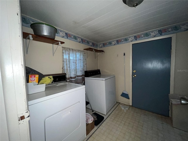 clothes washing area with light floors, laundry area, and washing machine and clothes dryer