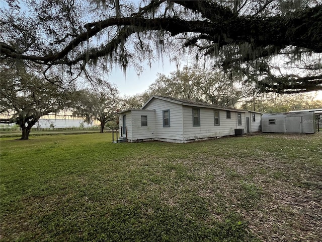 exterior space with a lawn and central AC