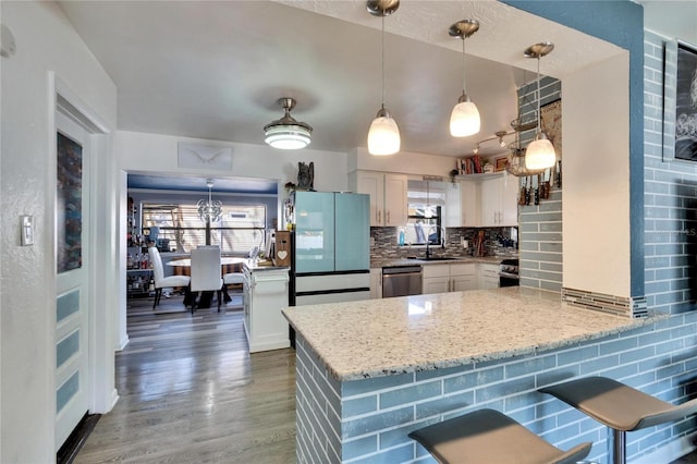 kitchen featuring backsplash, appliances with stainless steel finishes, wood finished floors, plenty of natural light, and white cabinets