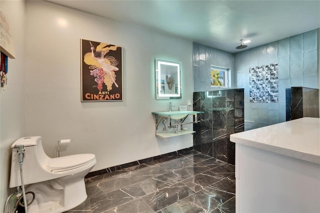 bathroom with a walk in shower, baseboards, toilet, marble finish floor, and vanity