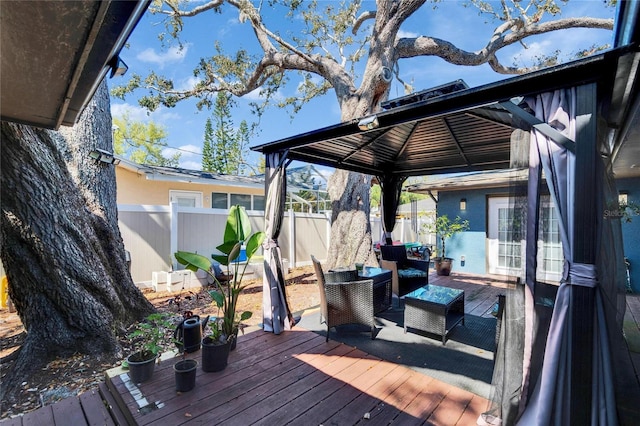 wooden deck with a gazebo, outdoor lounge area, and fence