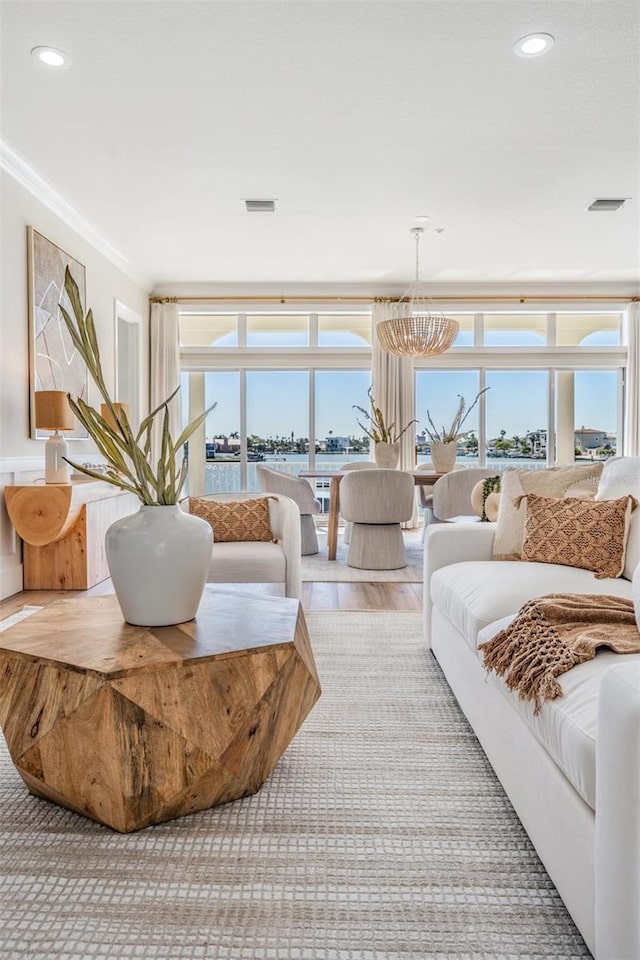 living room featuring recessed lighting, wood finished floors, visible vents, and ornamental molding