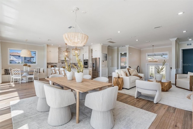 dining room featuring ornamental molding, recessed lighting, light wood-type flooring, and a chandelier