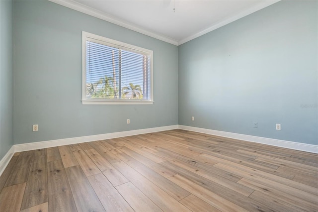 unfurnished room featuring crown molding, baseboards, and light wood-type flooring