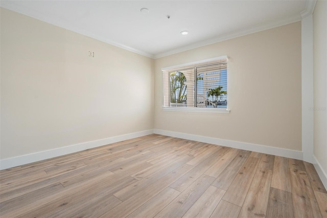 unfurnished room with light wood-type flooring, baseboards, and ornamental molding