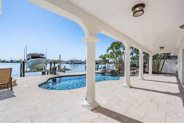 view of pool with a patio, a dock, a pool with connected hot tub, a water view, and boat lift