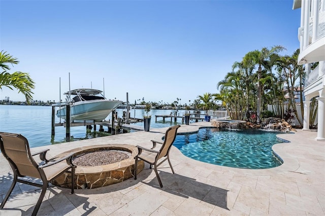 view of pool with a pool with connected hot tub, a dock, an outdoor fire pit, boat lift, and a patio area