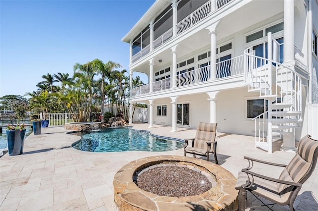 view of pool with a patio area, stairway, a pool with connected hot tub, and fence