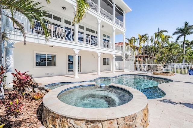 view of pool with a fenced in pool, an in ground hot tub, a patio, and fence