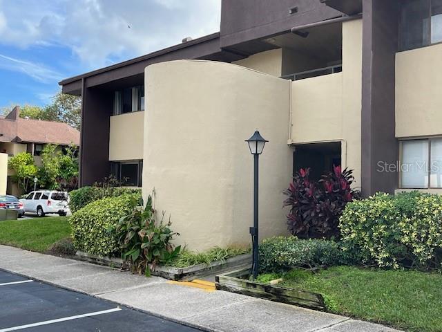 730 S Village Dr N Unit 101, Saint Petersburg, FL 33716 - view of property exterior featuring uncovered parking and stucco siding