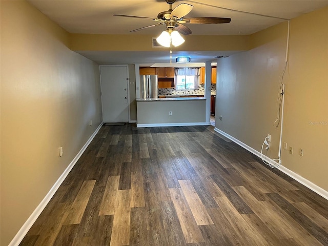 unfurnished living room with dark wood finished floors, visible vents, baseboards, and ceiling fan