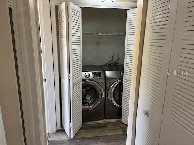 laundry area featuring laundry area, wood finished floors, and washing machine and clothes dryer