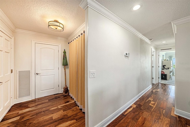 corridor with visible vents, ornamental molding, a textured ceiling, dark wood-style floors, and baseboards