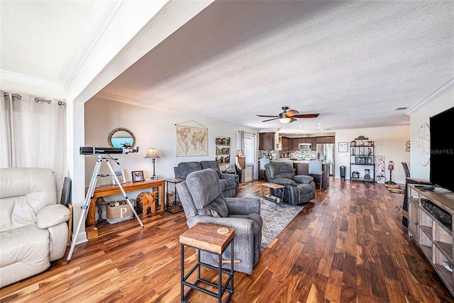 living room featuring a textured ceiling, crown molding, and wood finished floors