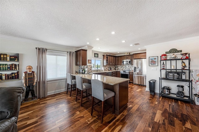 kitchen featuring light stone countertops, dark wood-style floors, a peninsula, appliances with stainless steel finishes, and open floor plan