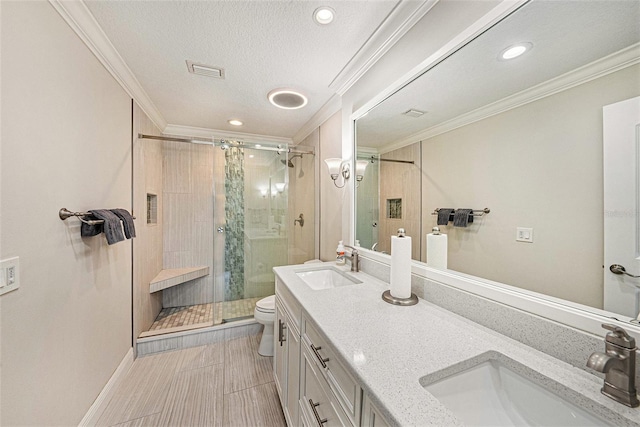 bathroom with a sink, toilet, a stall shower, and crown molding