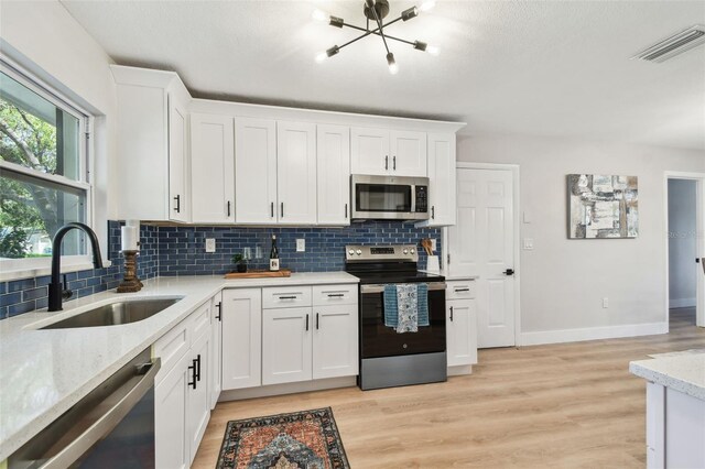 kitchen with light wood-type flooring, visible vents, appliances with stainless steel finishes, and a sink