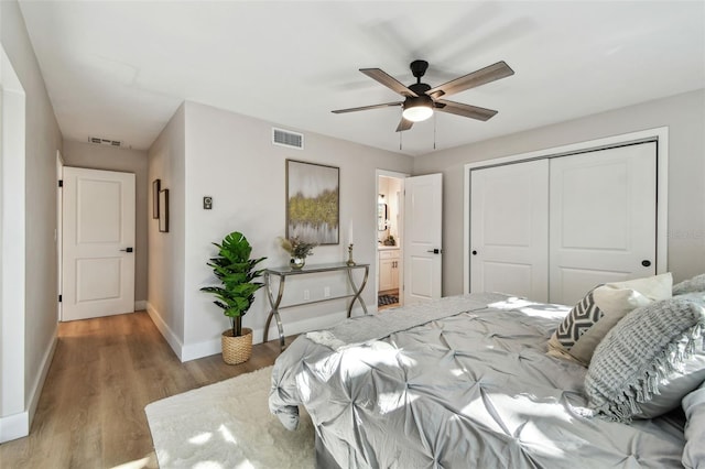 bedroom with visible vents, baseboards, a closet, and wood finished floors