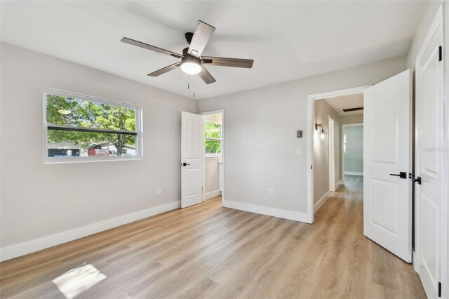 bedroom featuring ceiling fan, light wood-style floors, and baseboards