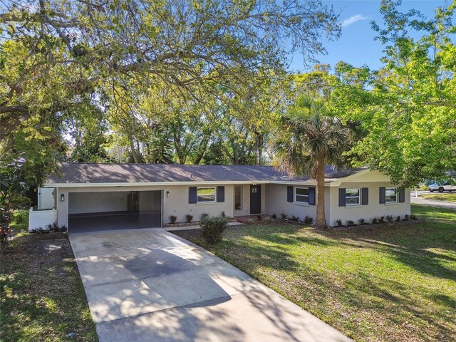 ranch-style home with driveway and a front lawn