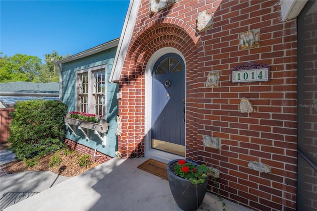 doorway to property featuring brick siding