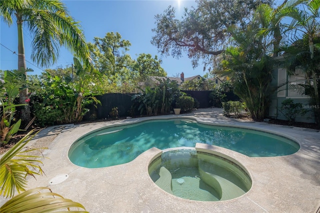 view of pool featuring a fenced backyard and a pool with connected hot tub