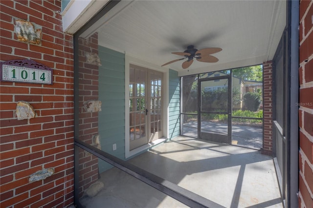 unfurnished sunroom with plenty of natural light and a ceiling fan