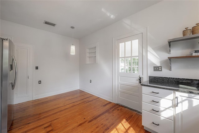 kitchen with visible vents, open shelves, stainless steel fridge with ice dispenser, light wood finished floors, and baseboards