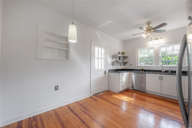 kitchen featuring dishwasher, dark countertops, light wood finished floors, and open shelves