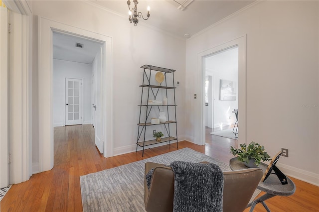 living area featuring baseboards, light wood-style floors, and crown molding