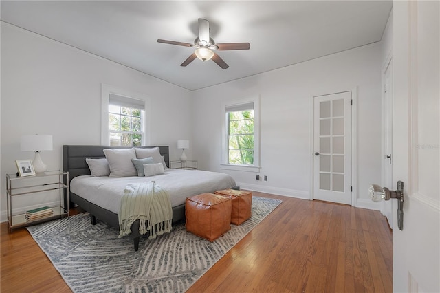 bedroom featuring a ceiling fan, baseboards, and wood finished floors