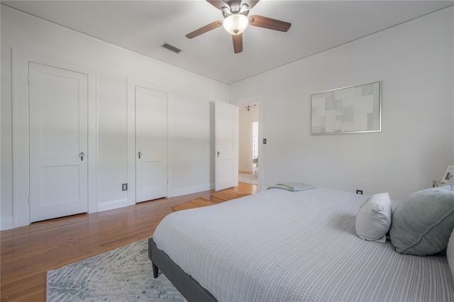 bedroom with visible vents, ceiling fan, and wood finished floors