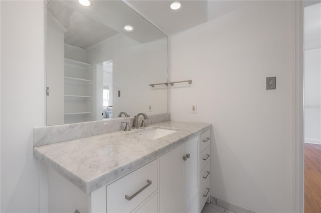 bathroom with recessed lighting, baseboards, and vanity