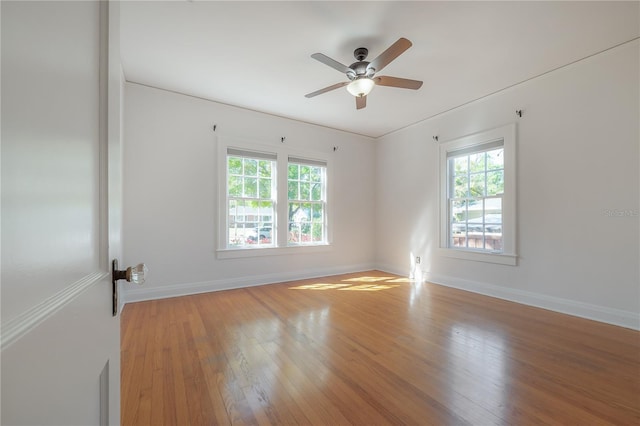 empty room featuring hardwood / wood-style floors, a healthy amount of sunlight, and ceiling fan