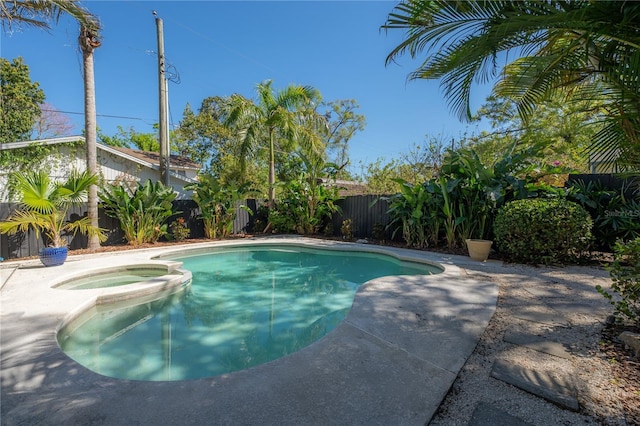 view of swimming pool featuring a pool with connected hot tub and a fenced backyard