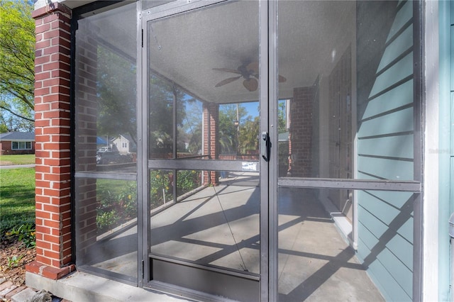 unfurnished sunroom with ceiling fan