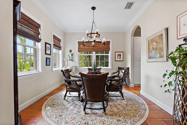 tiled dining area featuring arched walkways, visible vents, a wealth of natural light, and baseboards