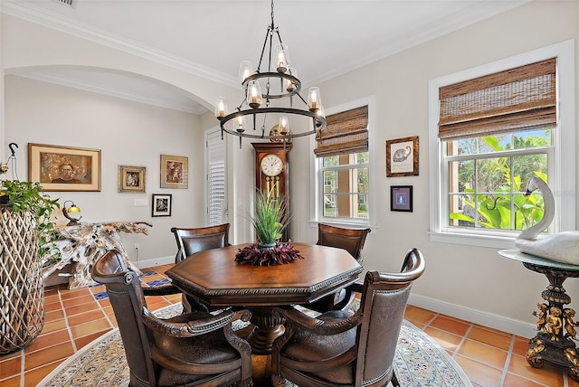 dining area featuring tile patterned flooring, crown molding, baseboards, and arched walkways