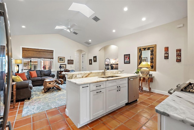 kitchen with visible vents, lofted ceiling with skylight, appliances with stainless steel finishes, arched walkways, and a sink