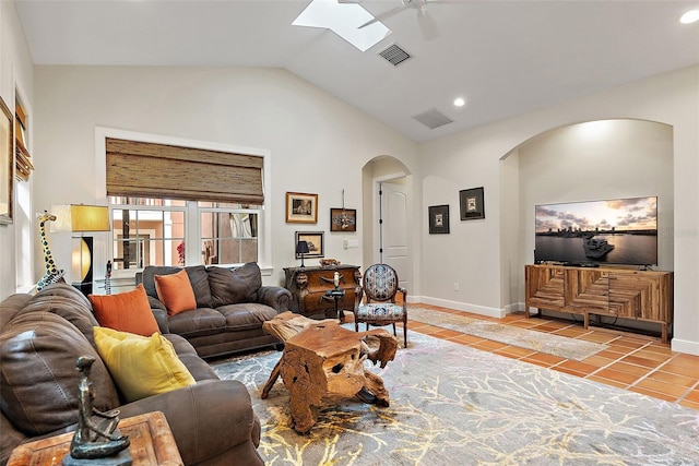 living room featuring tile patterned flooring, visible vents, baseboards, and vaulted ceiling