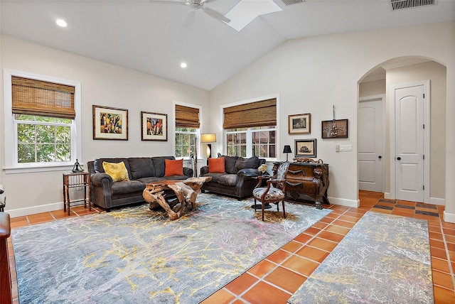 living area with a wealth of natural light, baseboards, arched walkways, and tile patterned floors