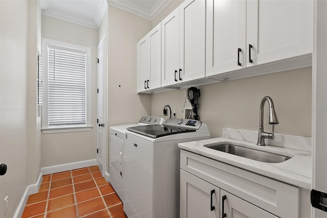 clothes washing area featuring crown molding, baseboards, washing machine and dryer, cabinet space, and a sink