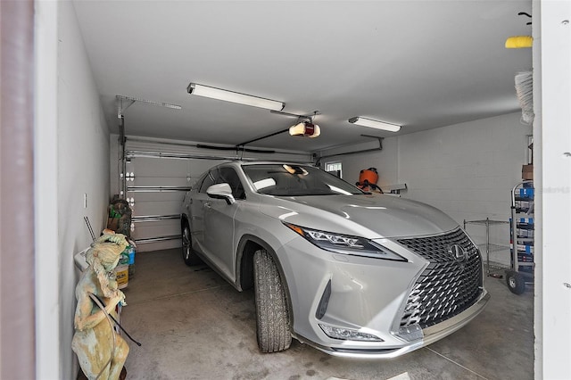 garage featuring a garage door opener and concrete block wall