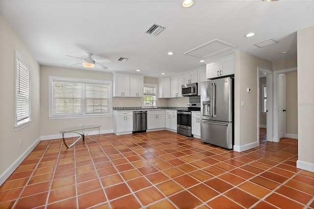 kitchen featuring tile patterned flooring, white cabinets, visible vents, and appliances with stainless steel finishes