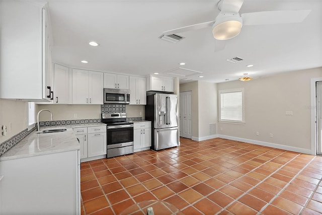 kitchen with a sink, visible vents, appliances with stainless steel finishes, and white cabinetry