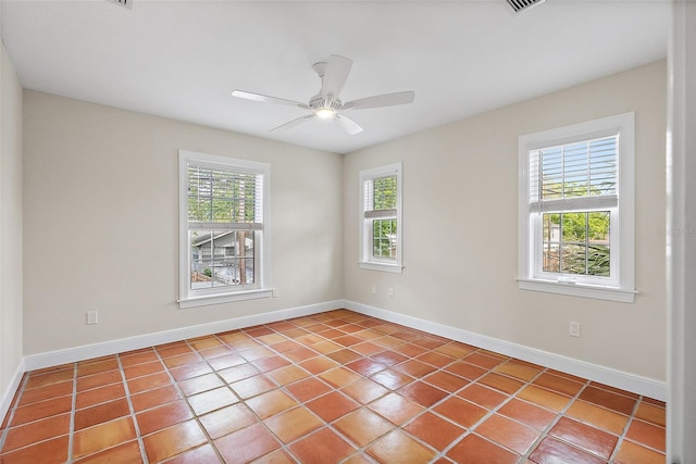 tiled empty room with visible vents, baseboards, and ceiling fan