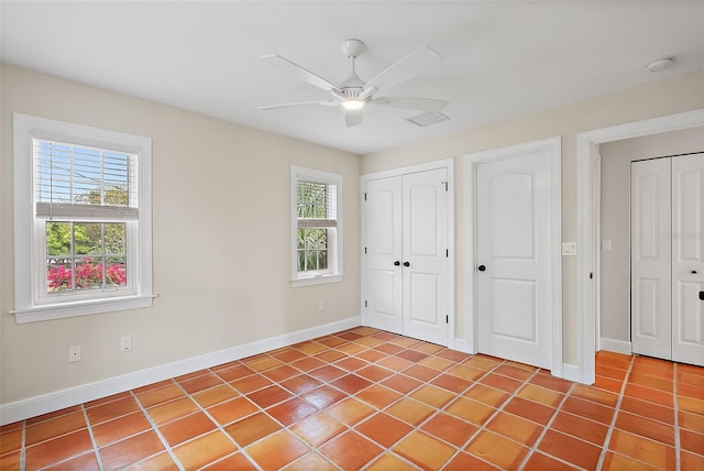 unfurnished bedroom featuring tile patterned flooring, ceiling fan, a closet, and baseboards