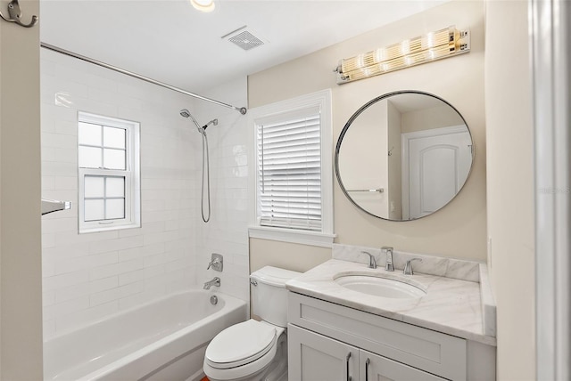 bathroom featuring vanity, toilet, visible vents, and shower / washtub combination