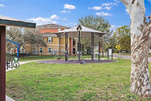 view of home's community featuring playground community, a lawn, and fence