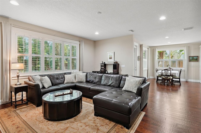 living area with hardwood / wood-style floors, recessed lighting, visible vents, and a textured ceiling